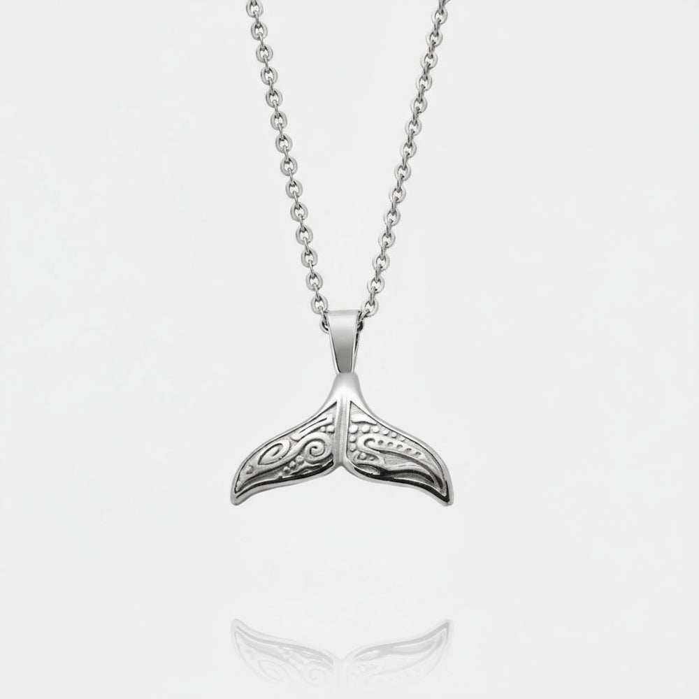Silver whale tail pendant on a chain against a white background