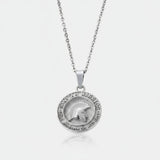 Silver necklace with a round pendant on a light gray background