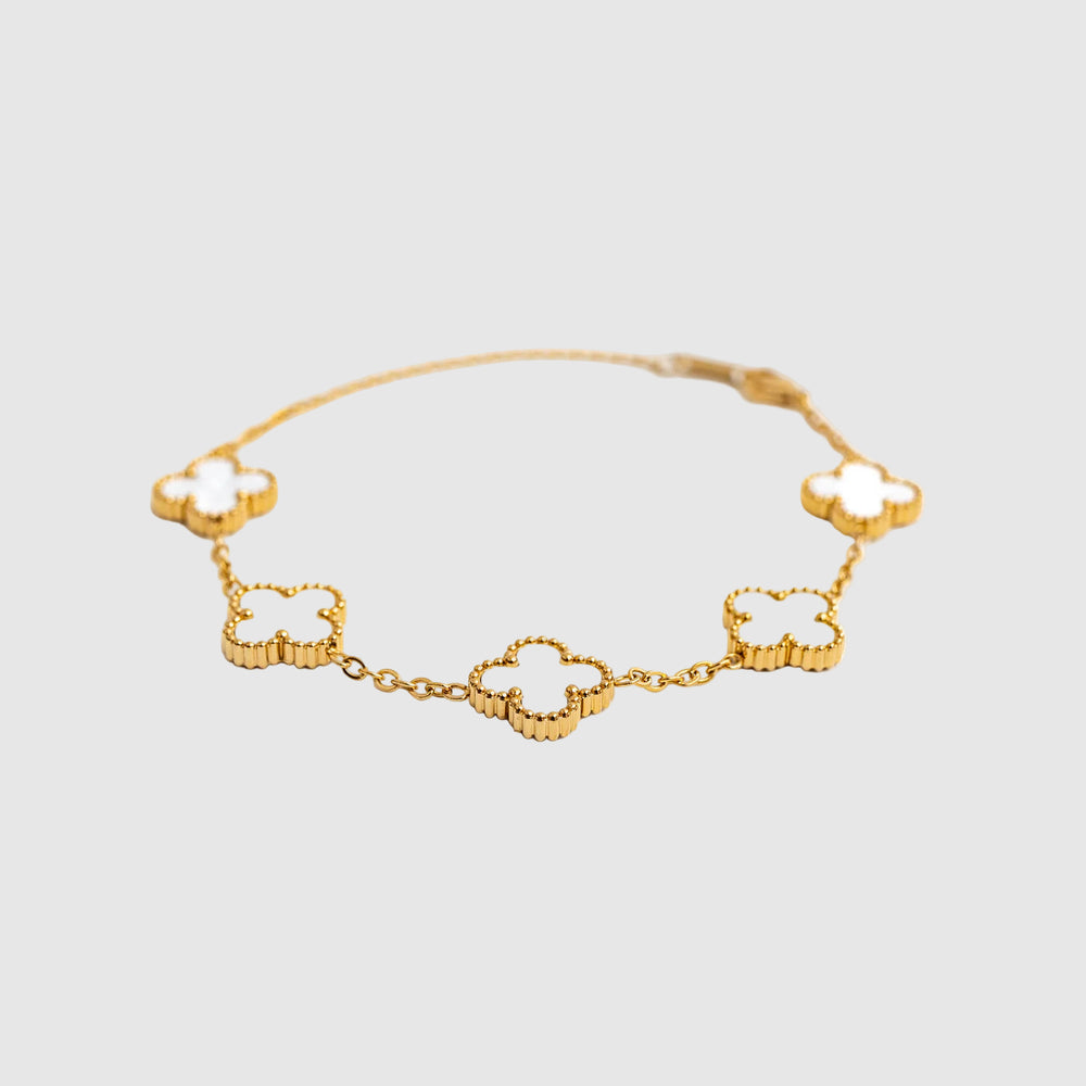 Gold bracelet with clover-shaped links on a white background