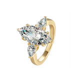 Gold ring with three diamonds on a light gray background