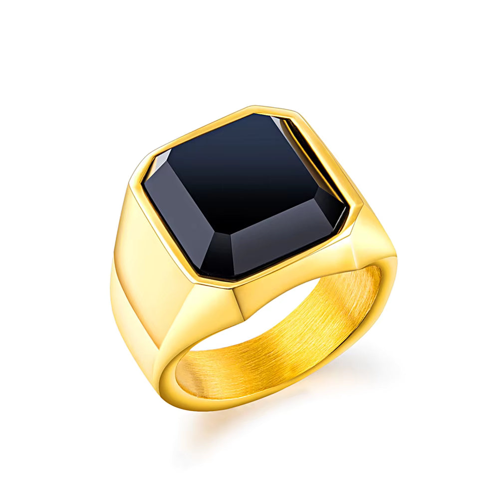 Gold ring with a black gemstone on a white background