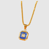 Gold necklace with a blue pendant on a wooden surface