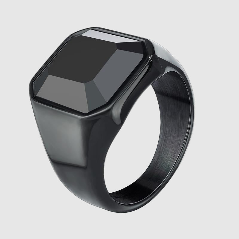 Black signet ring with a faceted black stone on a white background