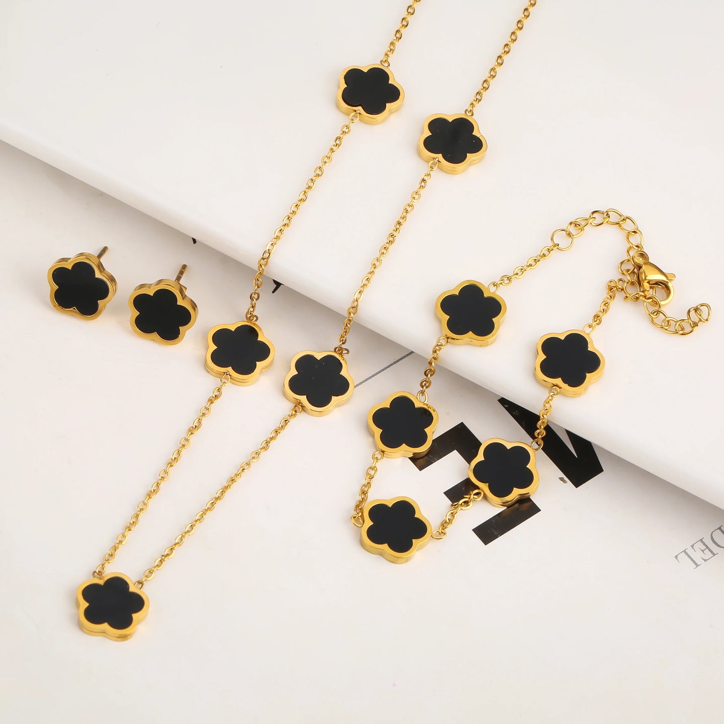 Elegant FLÔR no.5 set featuring black clover charms chain, bracelet and earrings