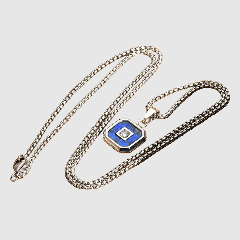 Silver necklace with a blue and black pendant on a wooden surface