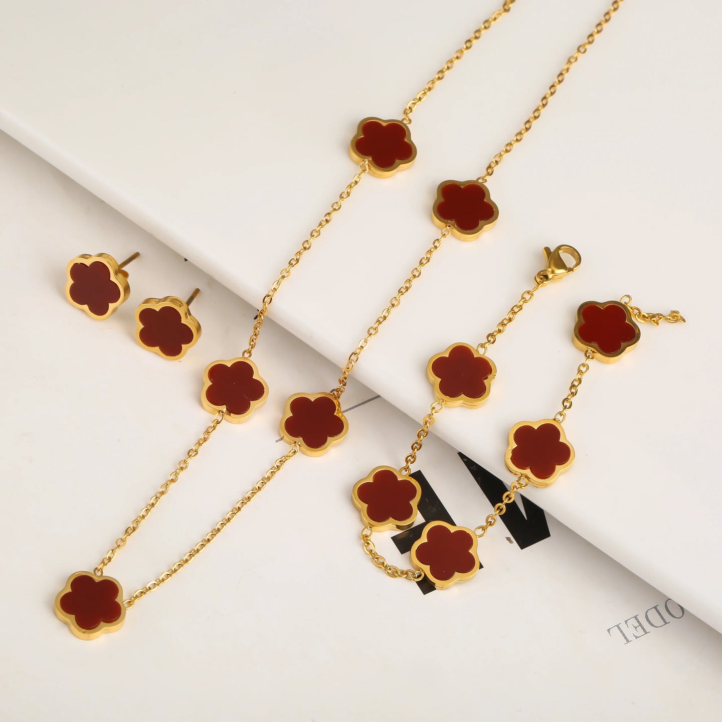 Elegant FLÔR no.5 set featuring ruby red clover charms chain, bracelet and earrings