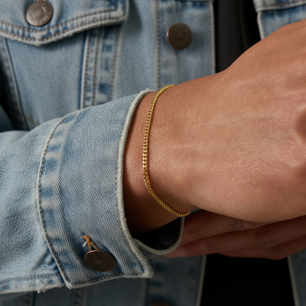 Gold bracelet on a wrist with a denim jacket