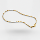 Gold chain necklace on a light gray background