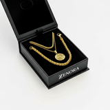 Gold necklace and chain in a black 'Zenora' jewelry box on a white background