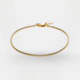 Gold bracelet on a light gray background