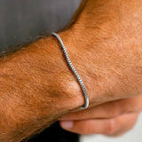 Silver bracelet on a person's wrist with a blurred background