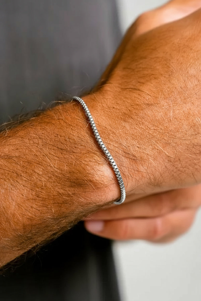 Silver bracelet on a person's wrist with a blurred background