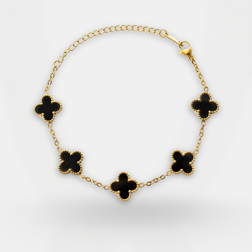 Gold bracelet with black clover-shaped charms on a white background