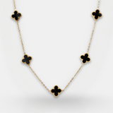 Necklace with black clover-shaped pendants on a light gray background