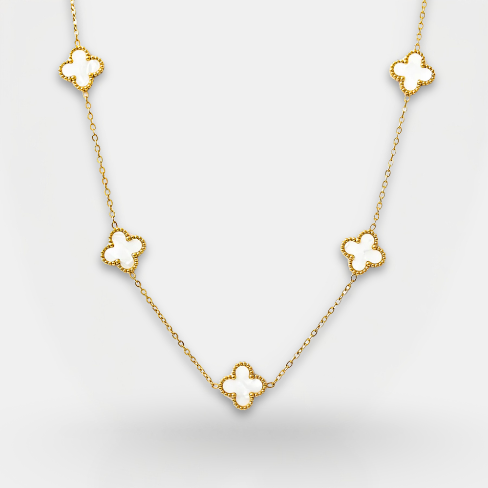 Gold necklace with clover-shaped pendants on a light gray background