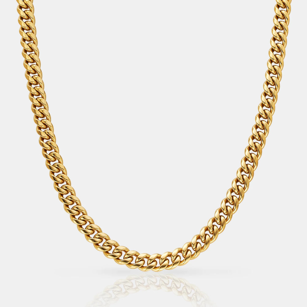 Gold chain necklace on a light gray background