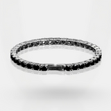 Silver ring with black gemstones on a light gray background