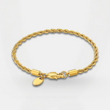 Gold bracelet with a clasp and small round charm on a light gray background