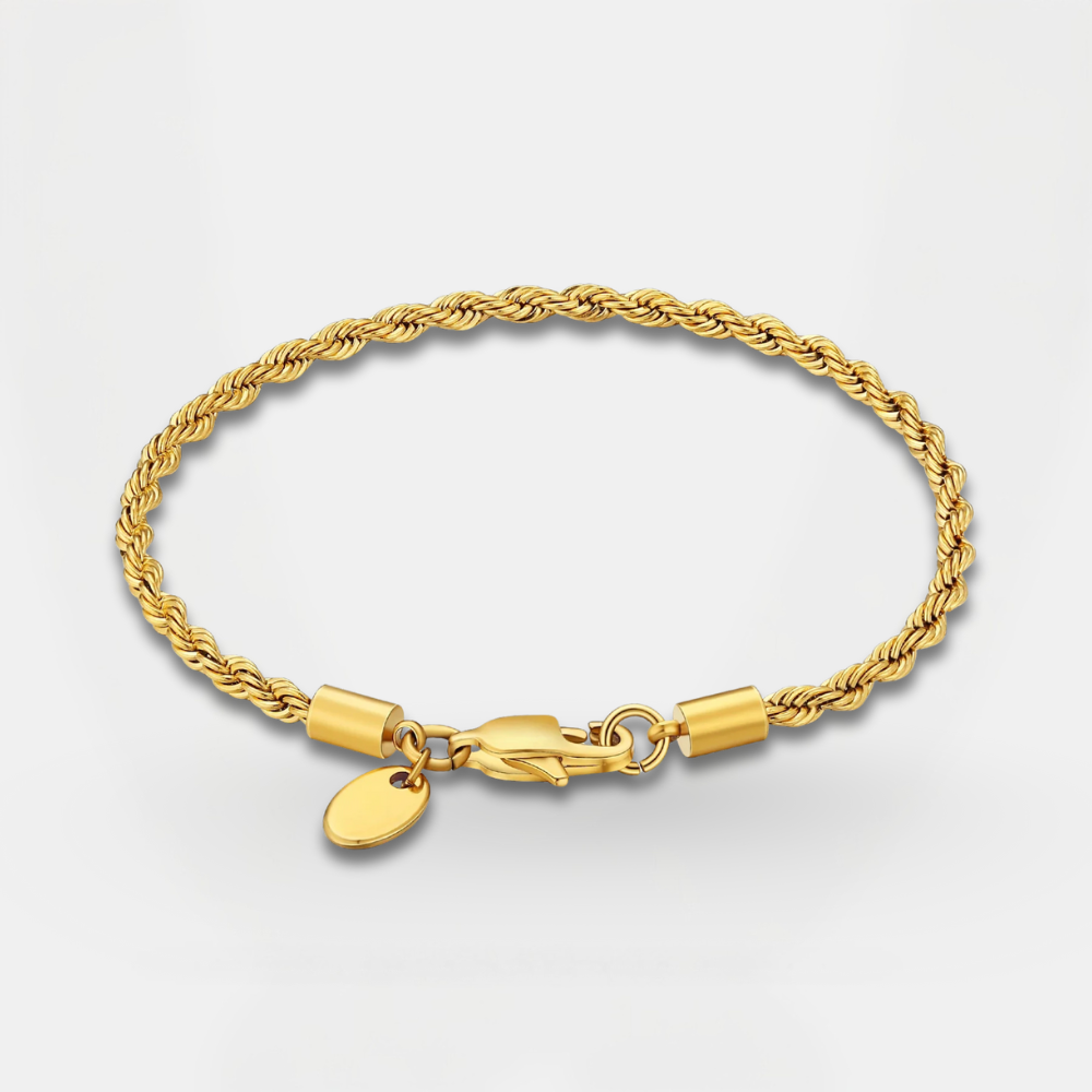 Gold bracelet with a clasp and small round charm on a light gray background