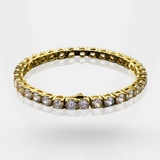 Gold bracelet with clear stones on a white background