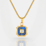 Gold necklace with a blue pendant featuring a central gemstone on a white background