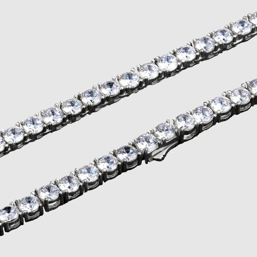 Two diamond tennis bracelets on a black background
