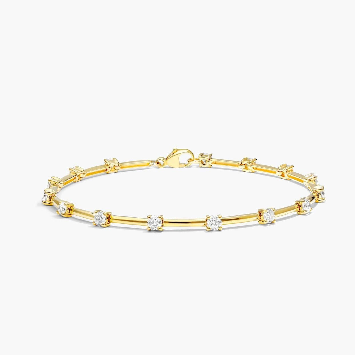 Gold bracelet with small diamonds on a white background