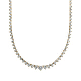 Gold necklace with clear stones on a light gray background