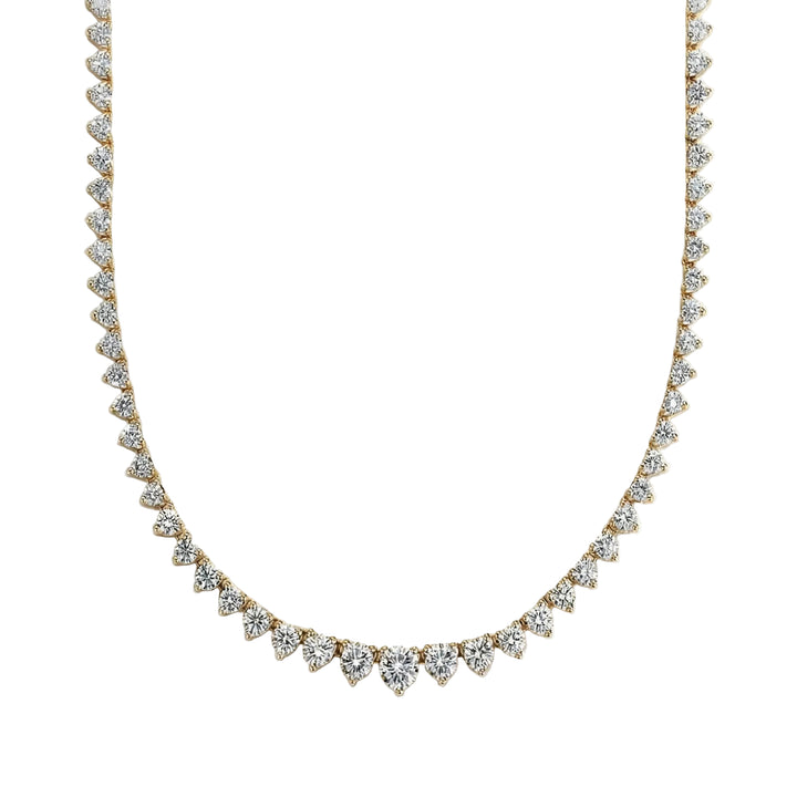 Gold necklace with clear stones on a light gray background