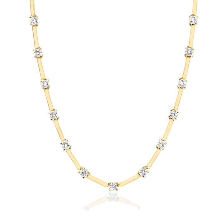 Gold necklace with diamond beads on a white background