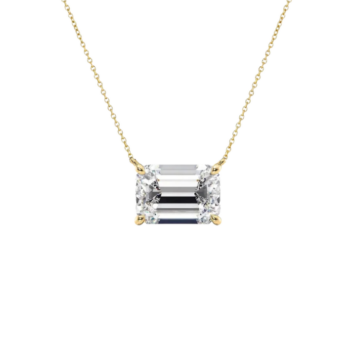An emerald-cut diamond pendant necklace in a yellow gold setting on a delicate gold chain, shown against a plain white background.