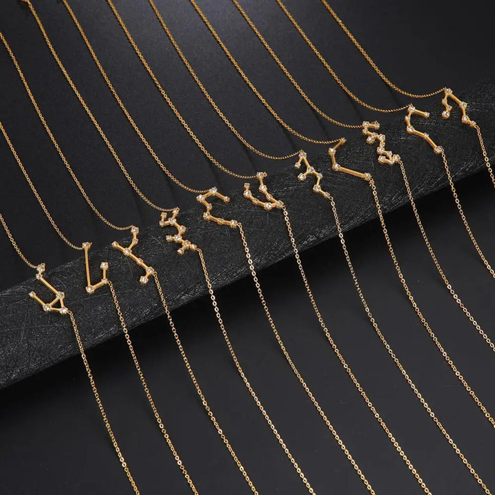 Gold necklaces with zodiac constellation pendants on a black background