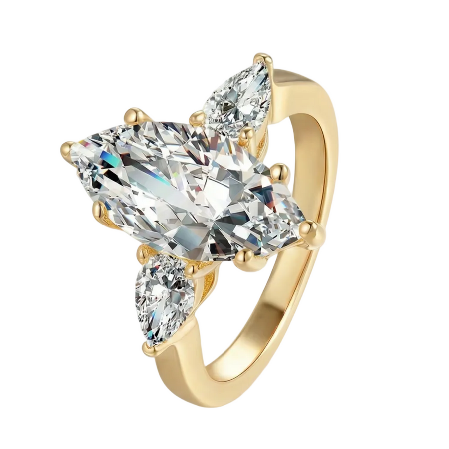 Gold ring with three diamonds on a light gray background